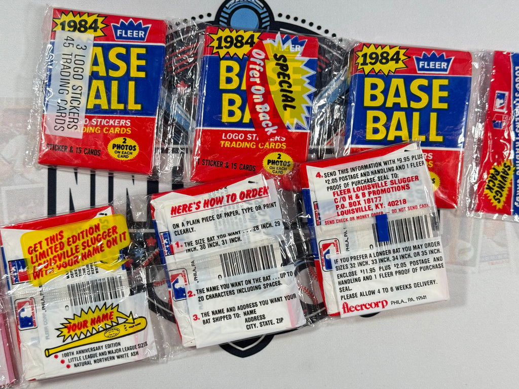 Collection of 1984 Fleer baseball trading card packs on a white background