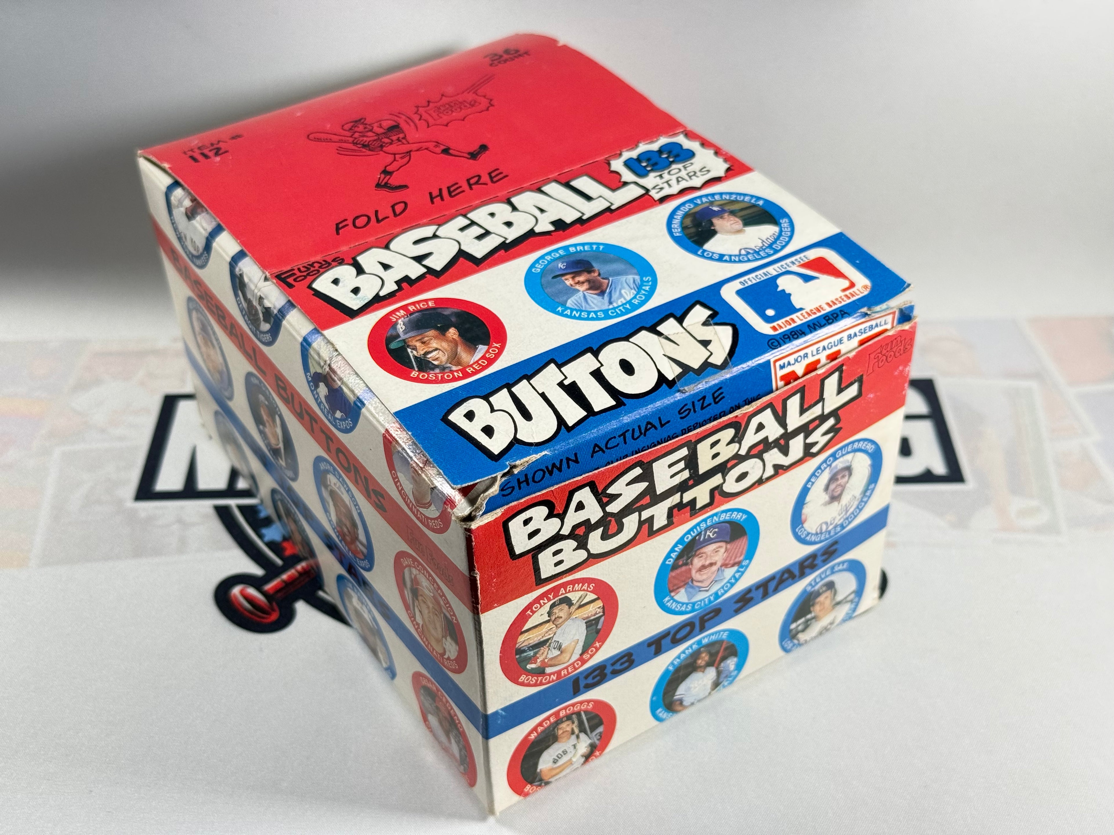 Box of baseball buttons with images of players on a white background