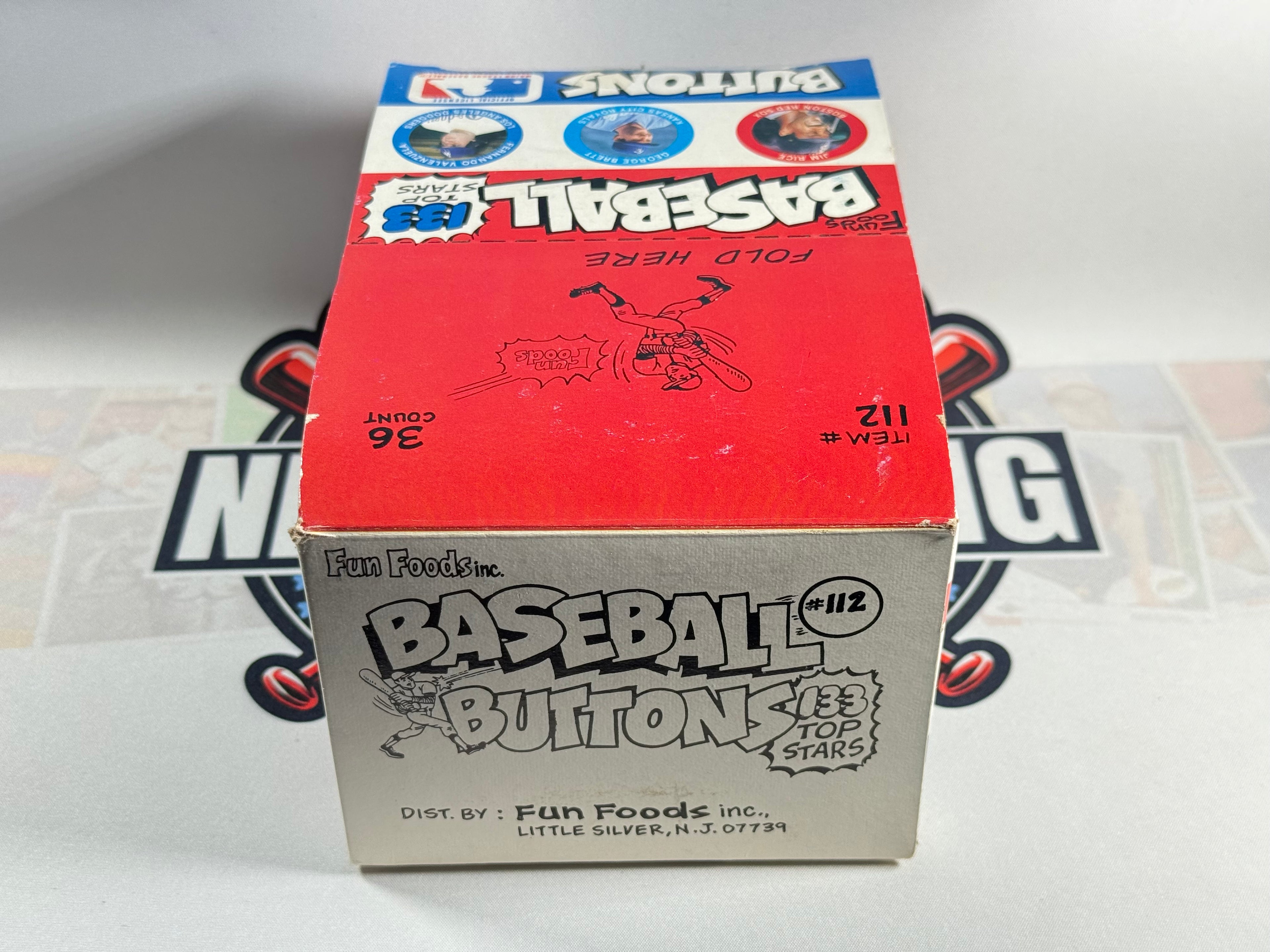 Box of baseball buttons with branding on a white background