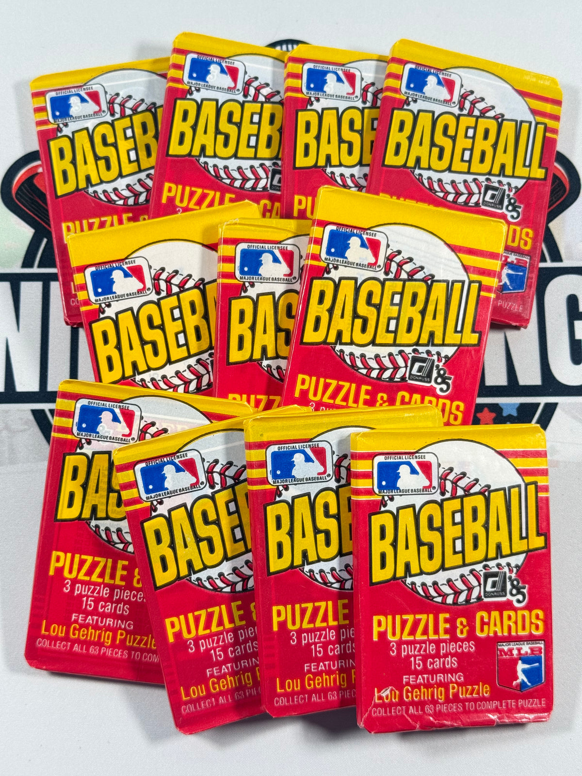 A stack of vintage 1985 MLB Baseball Puzzle & Cards trading card packs, featuring red and yellow packaging with the MLB logo and 'BASEBALL' in large letters.