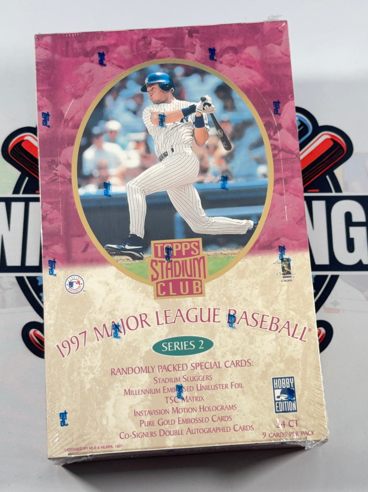 A sealed 1997 Topps Stadium Club Series 2 9-card booster pack for Major League Baseball, featuring a pink and beige design with a central image of a baseball player.