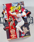 A Topps 1998 Major League Baseball Series 1 card booster box shown standing upright on a white surface with a blurred branded backdrop.