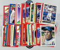 Collection of baseball trading cards featuring various players on a gray surface.