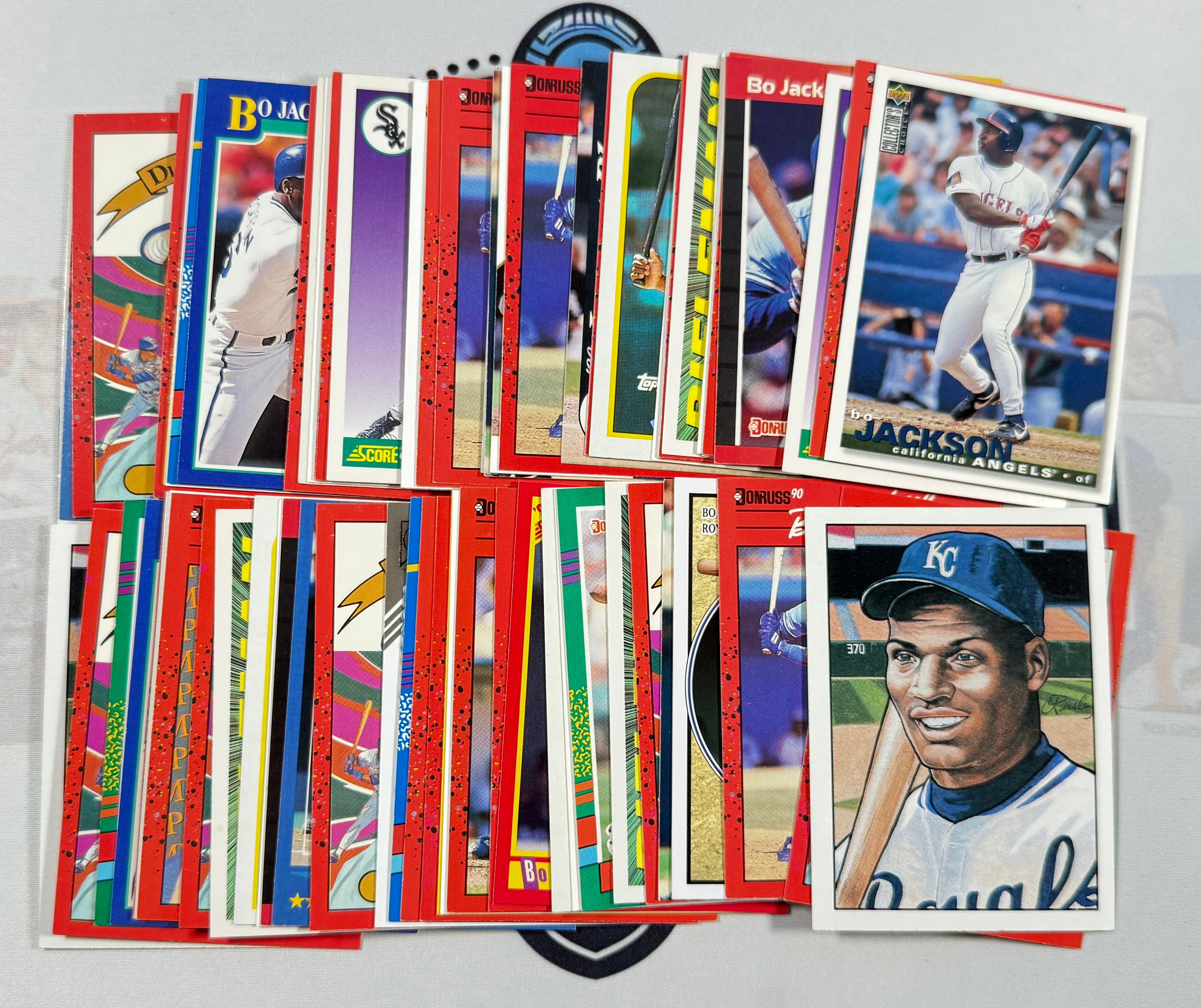 Collection of baseball trading cards featuring various players on a gray surface.