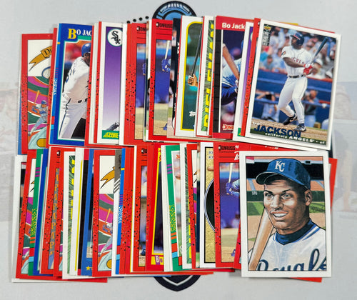 Collection of baseball trading cards featuring various players on a gray surface.
