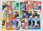 Collection of baseball trading cards featuring various players on a white surface.