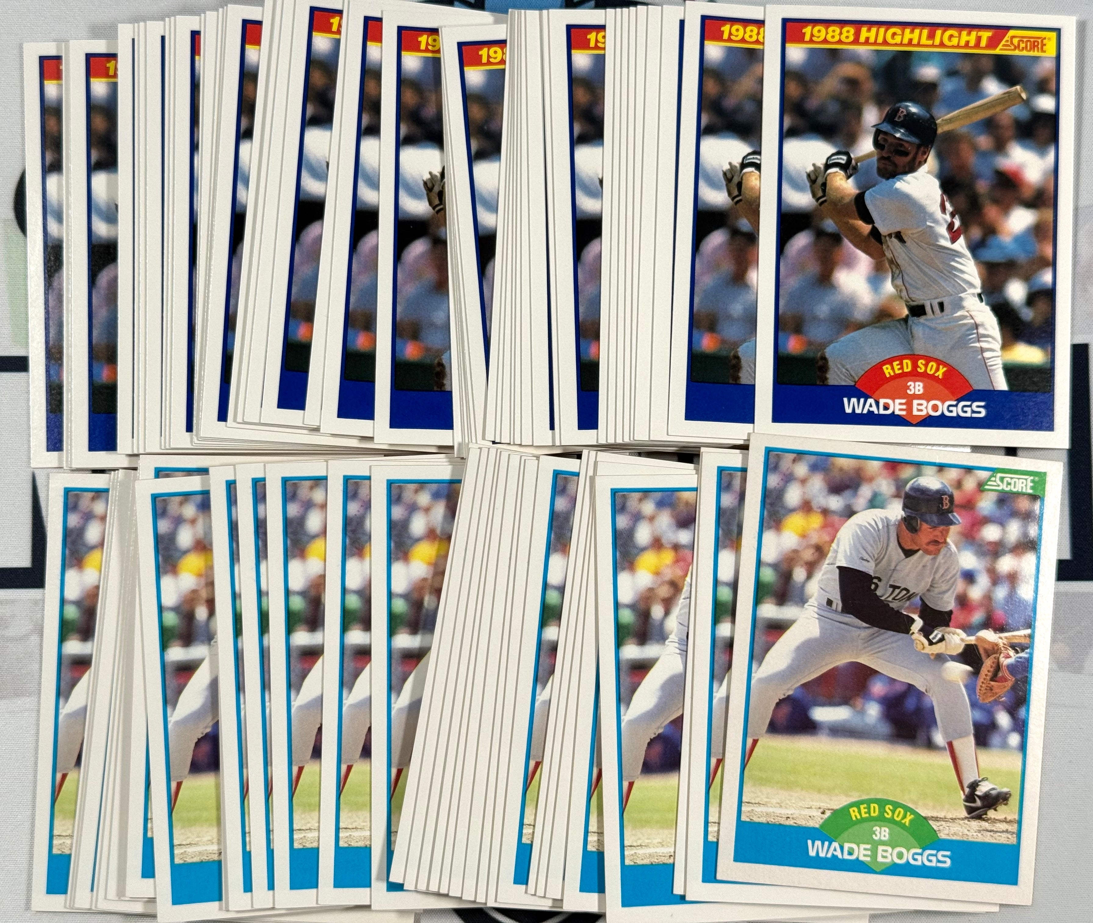 Collection of baseball trading cards featuring players, including Wade Boggs, on a gray surface.