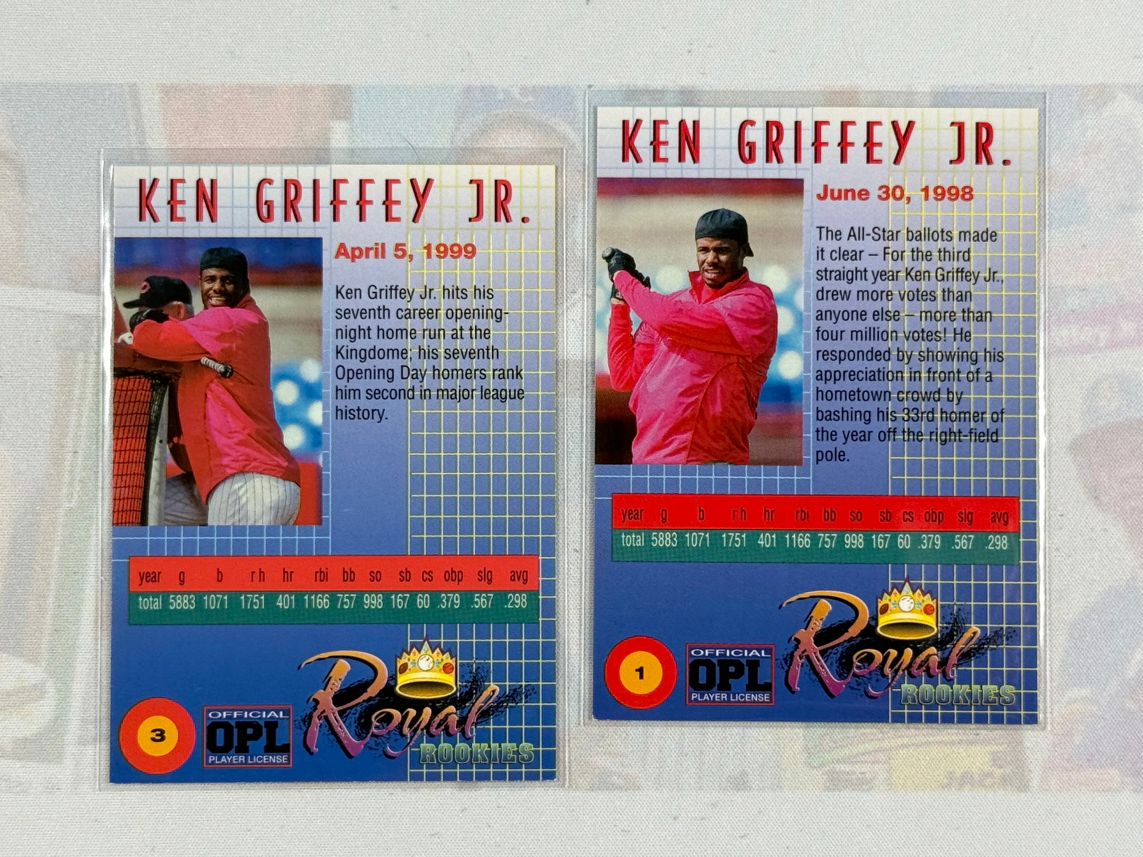 Two trading cards featuring Ken Griffey Jr. on a textured surface