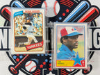 Two baseball trading cards featuring Reggie Jackson and Tim Raines on a decorative background with sports-themed elements.