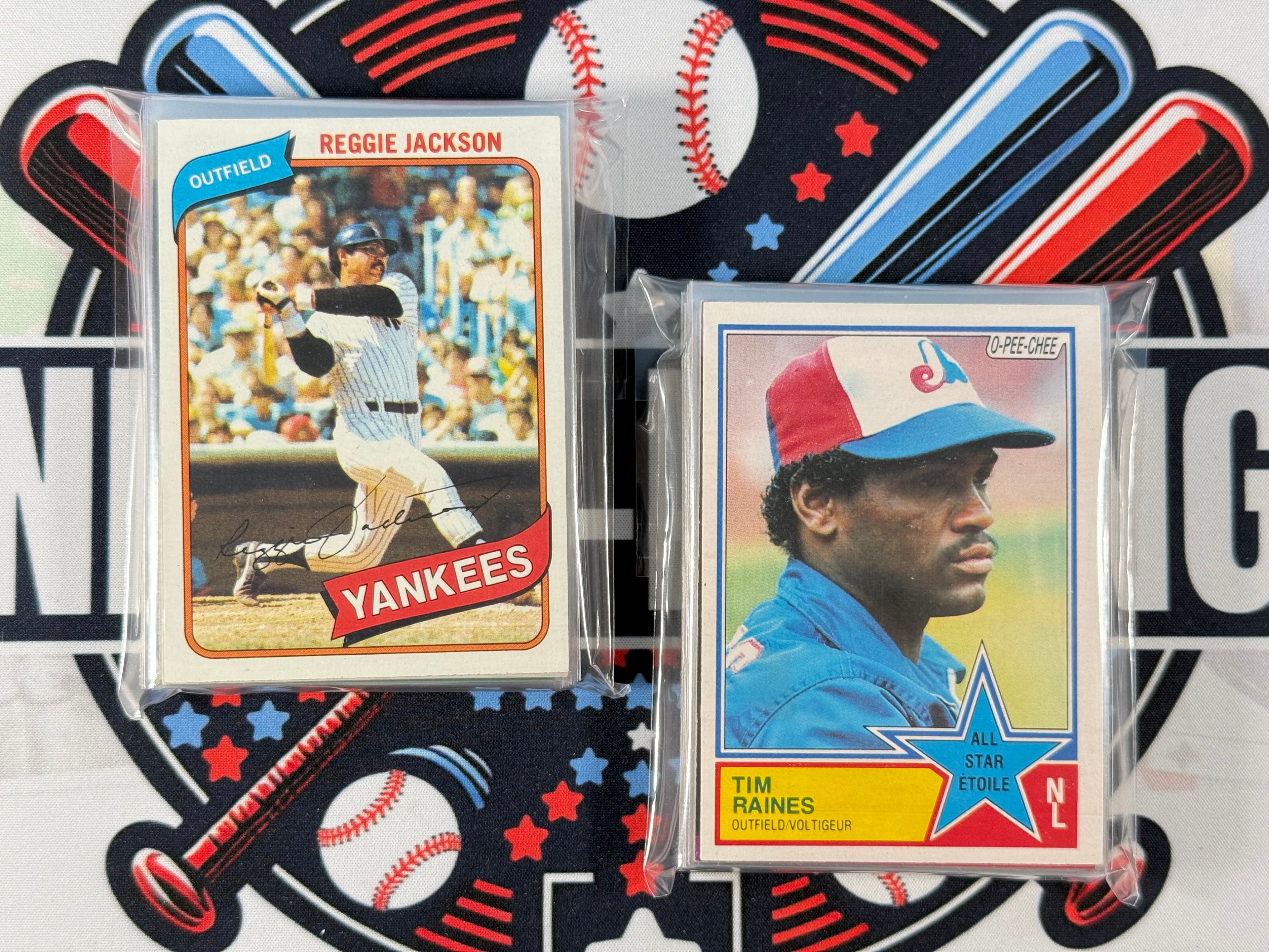 Two baseball trading cards featuring Reggie Jackson and Tim Raines on a decorative background with sports-themed elements.